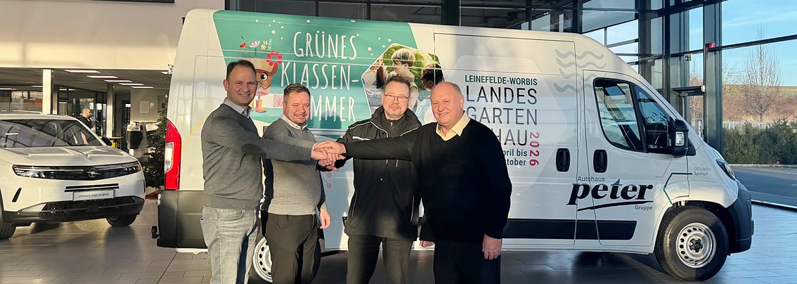 Vier M&auml;nner stehen in einem Autohaus vor einem wei&szlig;en Citroen Jumper und l&auml;cheln in die Kamera.