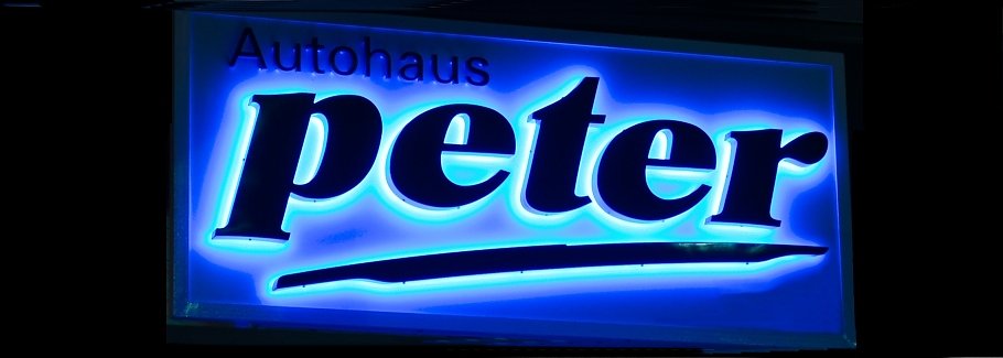 Firmenschild Autohaus Peter (Foto: Autohaus Peter) Leuchtendes Firmenschild mit der Aufschrift Autohaus Peter, Text mit blau leuchtendem Hintergrund.