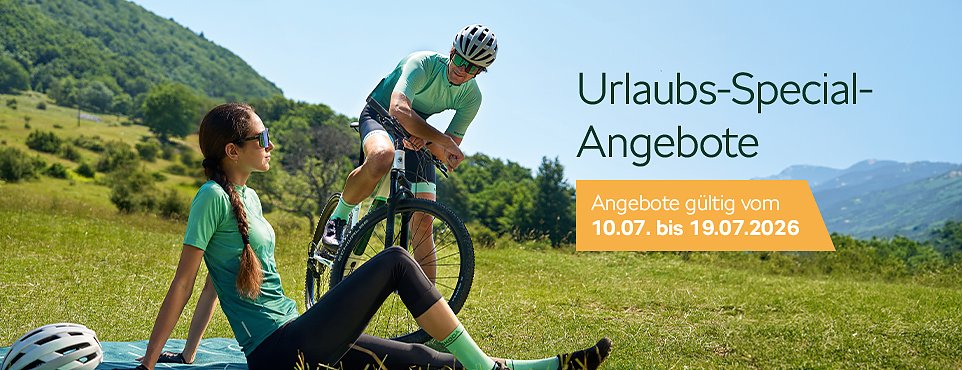 Zwei Radfahrer machen Pause auf einer Wiese, beworben mit Urlaubs-Special-Angeboten.
