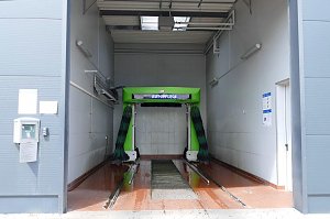 Moderne Waschanlage mit grünem Schriftzug �Autopflege� in einer hellen Halle, bereit für die Fahrzeugreinigung.