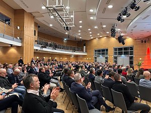 Gro&szlig;e Ansicht des Publikums: Zahlreiche G&auml;ste sitzen im Saal und applaudieren w&auml;hrend der Er&ouml;ffnung.