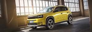 Ein leuchtend gelber Fiat Grande Panda steht schr&auml;g von vorn fotografiert in einer lichtdurchfluteten Industriehalle. Das kompakte SUV im B-Segment hat markante schwarze Akzente an Front, Radk&auml;sten und Dachreling. Auf der Seite ist dezent der Schriftzug PANDA eingearbeitet. Sonnenlicht f&auml;llt durch hohe Fenster und spiegelt sich auf der gl&auml;nzenden Karosserie.
