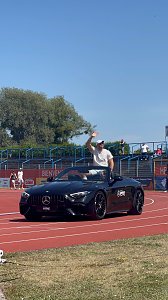 Ein schwarzes Mercedes-Benz Cabrio des Autohauses Peter f&auml;hrt &uuml;ber die rote Laufbahn beim Leichtathletik-Meeting Anhalt 2025. Ein Sportler winkt den Zuschauern auf der Trib&uuml;ne vom Cabrio aus zu.