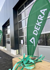 Aussenansicht den neuen Dekra Geb&auml;udes, davor eine gr&uuml;ne Beachflag mit Dekra-Logo
