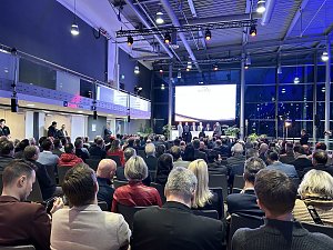 Großes Publikum in einer Messehalle, vorne Bühne mit Panel und Leinwand bei der Automobil Messe Erfurt.