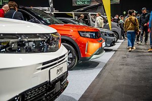 Fahrzeugreihe auf der Automesse, Besucher schauen sich Autos an.