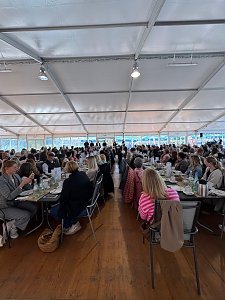 Großes Gastronomiezelt mit langen, voll besetzten Tafeln