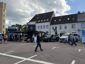 Man sieht unseren Promotion-Stand mit einem grauen Actros, einem schwarzen GLC und einer wei&szlig;en V-Klasse.