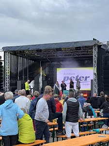 Blick auf die Eventbühne: Die feierliche Siegerehrung der Rawalympischen Spielee, im Hintergrund ist das Logo der Autohaus Peter Gruppe auf der großen LED-Leinwand über den Köpfen der Zuschauer.