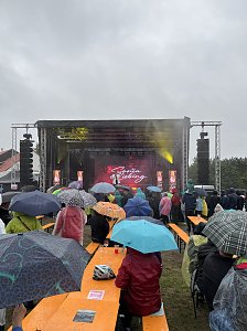 Schlagersängerin Sonia Liebing begeistert das Publikum, das unter bunten Regenschirmen feiert.