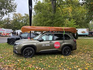 Subaru-Fahrzeug auf dem Messegelände mit Holzkajak auf dem Dach